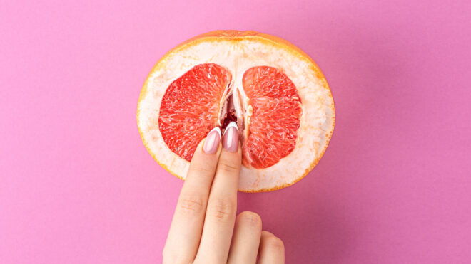 vabbing, fingers on grapefruit on pink background. Sex concept. sexy fruit composition. Vagina symbol.