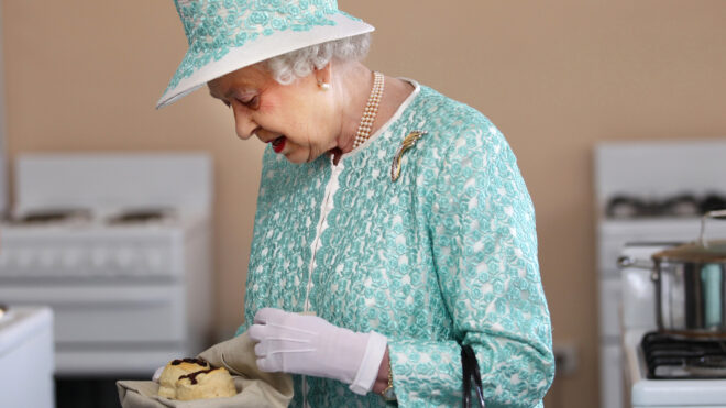 Britain's Queen Elizabeth II looks at homemade scones as she visits the kitchen at Clontarf Aboriginal College in Perth on October 27, 2011. The queen, who arrived in Perth on October 26, will officially open the 54-nation Commonwealth Heads of Government Meeting (CHOGM) on October 28 where revamping succession to the British throne will be discussed, concluding a 10-day tour of her antipodean realm. AFP PHOTO / POOL / SHARON SMITH (Photo credit should read SHARON SMITH/AFP via Getty Images)